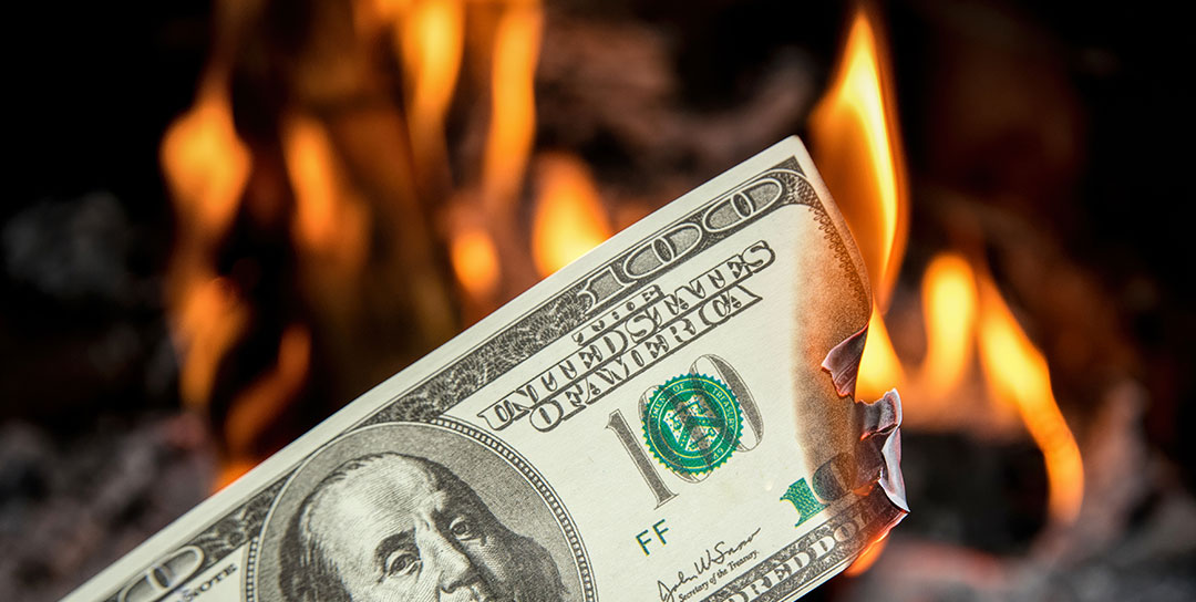 A $100 bill in a fireplace burning