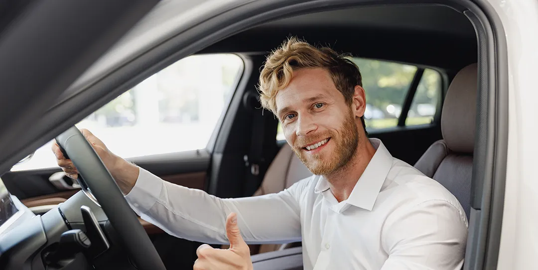 Man in car giving thumbs up.