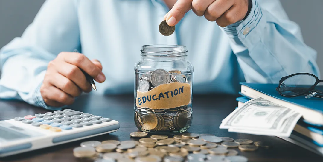 Putting money in a jar marked Education.