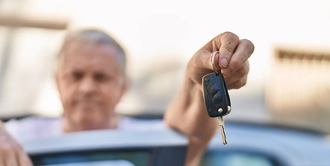 Man holding a key, auto refinancing concept